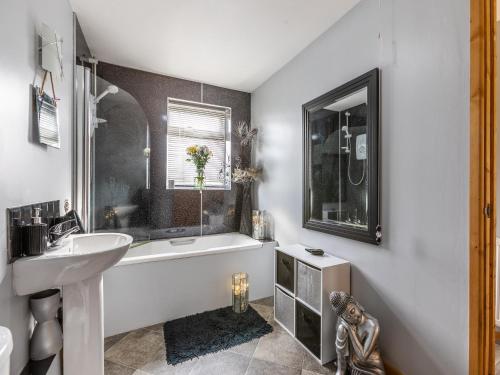 西蒙兹亚特Flyby Cottage的浴室配有白色浴缸、盥洗盆和浴缸。