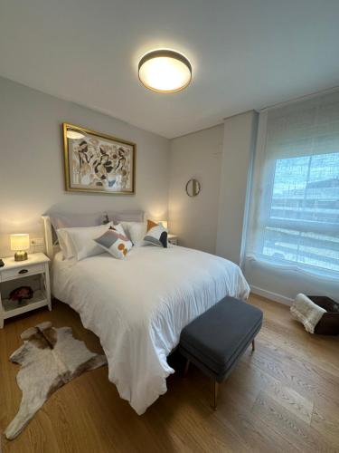 格乔A estrenar amplio con piscina y parking的卧室设有一张白色大床和一扇窗户。