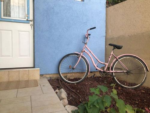 OvnatBeautiful Dead Sea Unit的一辆停在蓝色墙壁旁边的粉红色自行车