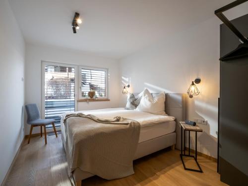 蒂罗尔州圣约翰Ferienwohnung Tirolglück mit großem Garten的卧室配有床、椅子和窗户。