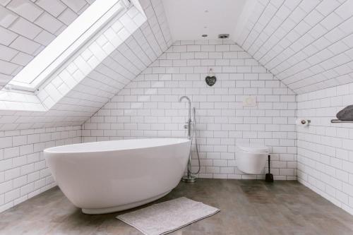 GartocharnDunruadh Cottage的白色的浴室设有浴缸和卫生间。