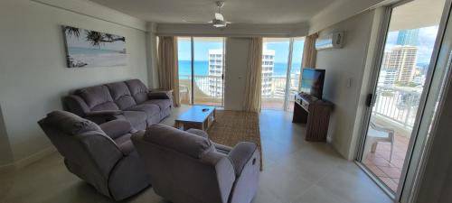 黄金海岸APR Private SUITES MOROC by the Beach的带沙发和电视的客厅以及阳台。