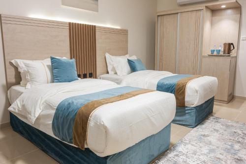 巴哈ابات بارك Abat Park的蓝色和白色的酒店客房内的两张床