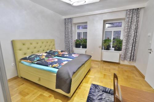 维也纳卢克斯尊贵公寓的一间卧室设有黄色的床和2个窗户。