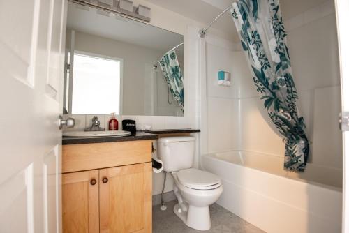 坎莫尔Renovated Chalet at Mystic Springs, Mountain Views, Pets Welcome!的浴室配有卫生间、浴缸和水槽。
