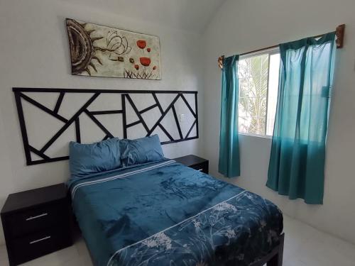 伊斯塔帕Casa el Palmar, the best house in Ixtapa的一间卧室配有一张带蓝色床单的床和一扇窗户。