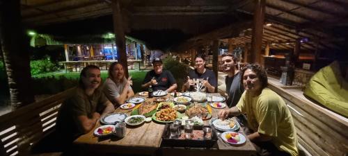 巴芝丹Istana Ombak Eco Resort的一群人坐在桌子旁吃着食物