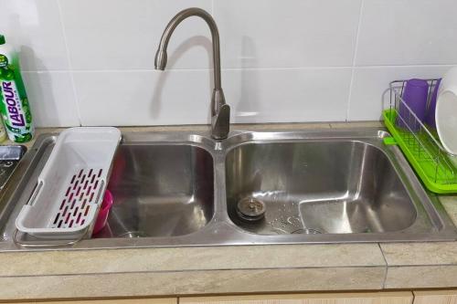 米里Sunsky Condominium Homestay的厨房水槽旁设有碗碟干燥架