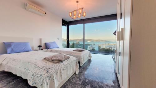 博德鲁姆Villa Çimentepe的一间卧室设有两张床和大窗户