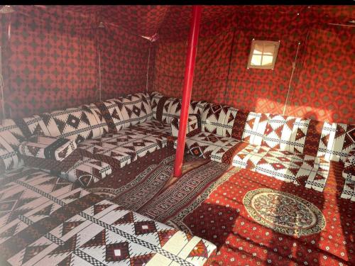 利雅德استراحة لبنان ا في بنبان Istraha的一间设有四张床的客房,位于带红色墙壁的房间内