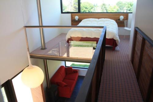 本塔纳山村Hoyo 6 Rincón del Golf的一间小卧室,配有一张床和一把红色椅子