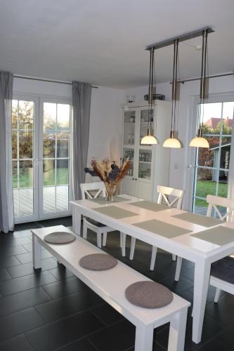 齐罗Auszeit am Meer的一间设有白色桌子和长凳的用餐室