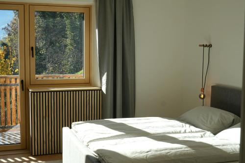 里菲亚诺Villa Vitis的卧室在窗户前配有一张床