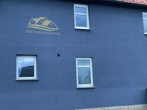 SchellertenMR Ferienwohnung - Einzelzimmer Lina的蓝色的建筑,有窗户和标志