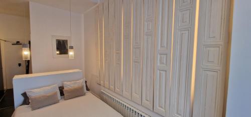 希洪Balcón del Puerto Luxury Suite的一间设有白色墙壁和两个枕头的客房