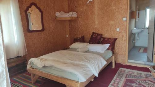 阿拉德Zman Midbar Eco Spirit Lodge for Peace的一张小床,位于带镜子的房间里