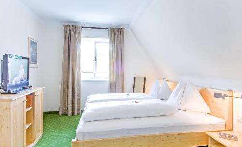 沃尔特湖畔佩莎赫Ferienhaus Kleine Gartenvilla的酒店客房设有两张床和电视。