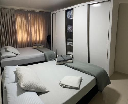波梅罗迪Apartamento em Pomerode的客房设有两张床和一个衣柜。
