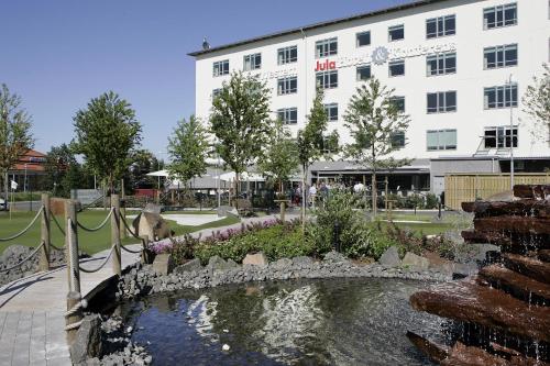 斯卡拉Skara Konsthotell的一座建筑前有池塘的酒店