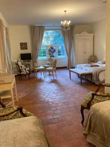 MalansacManoir de Saint-Fiacre的一间卧室配有两张床和电视。