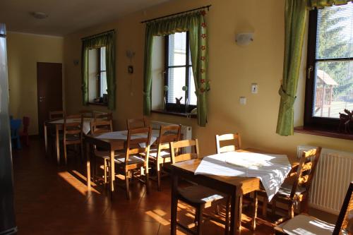 大洛西尼Penzion Fialka的用餐室设有桌椅和窗户。