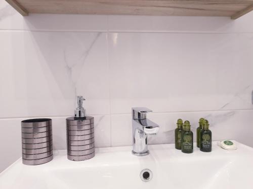 佩雷亚Eantos Studios and Suites的浴室水槽配有瓶子和水龙头