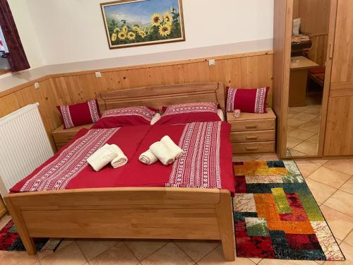 采尔克诺Apartment & Studio Forest Paradise的一间卧室配有一张带红色床单和枕头的床。