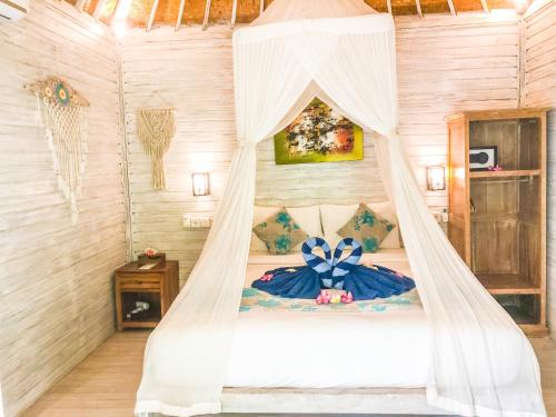 蓝梦岛The Lucky Cottage的一间卧室配有一张带蚊帐的床