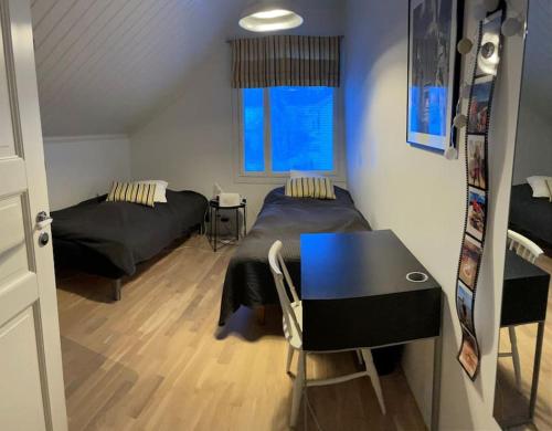 坦佩雷Modern 6-bedroom villa near Tampere city的一间卧室配有两张床、一张桌子和一张桌子