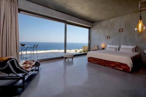 KoríthionStunning 180° Sea View Designer Villa for two的一间卧室设有一张床和一个大窗户