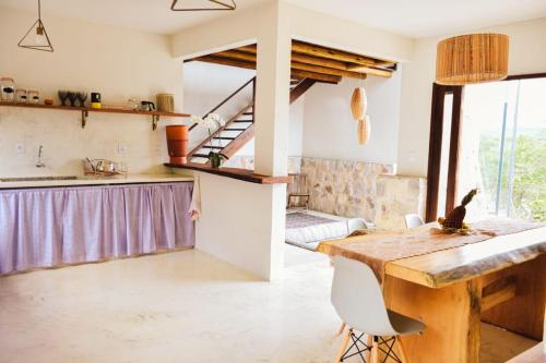 伦索伊斯Casa AMAR Piscinas Naturais的厨房以及带木桌的用餐室。