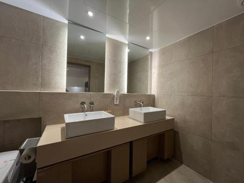 坡州市From H Sodo Hotel Paju的浴室设有2个水槽和镜子