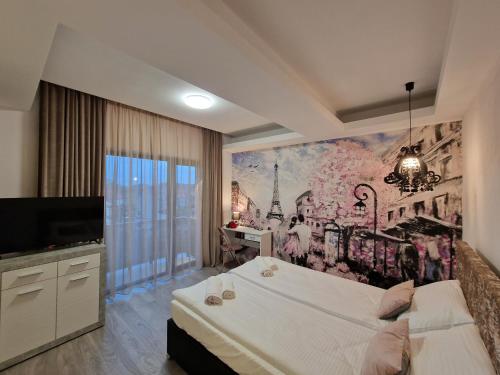 奥拉迪亚Art's Luxury Boutique Hotel的卧室配有一张大床,墙上挂有绘画作品