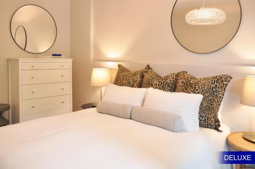巴塞罗那Mediterranean Barcelona Apartments的卧室配有一张白色床,墙上挂有两面镜子