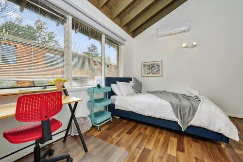 墨尔本Carlton Dream: Leafy 2bed 2bath Lygon Str Townhouse的一间卧室配有一张床、一张桌子和一把椅子