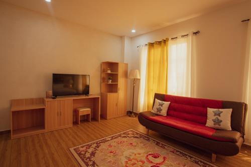Lower Princeʼs QuarterJuly AirBnB的客厅配有红色沙发和平面电视