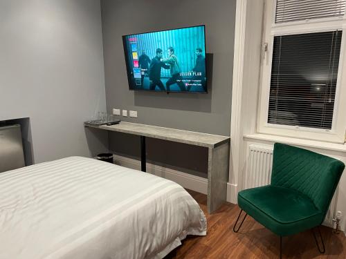 Laurieston Inn的卧室配有一张床,墙上配有电视