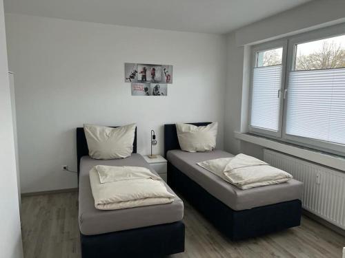 吕伯克Eine modern renovierte Wohnung mit Balkonterrasse.的带2扇窗户的客房内的2张床