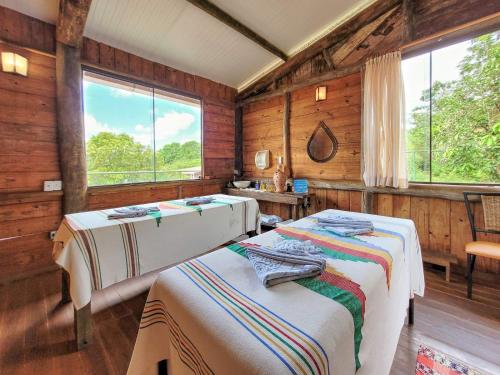 博尼图阿瓜斯德博尼托旅馆的配有木墙和窗户的客房内的两张床