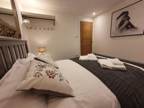 卢顿Luton Town Centre Executive Apartment的一间卧室配有一张大床和两个枕头