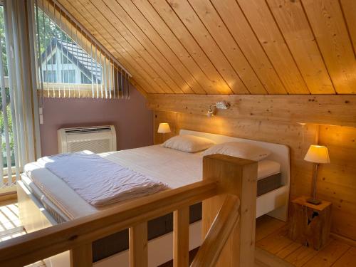 弗罗夏佩勒L'écureuil des Lacs-4 pers的木制客房内的一间卧室,配有一张床