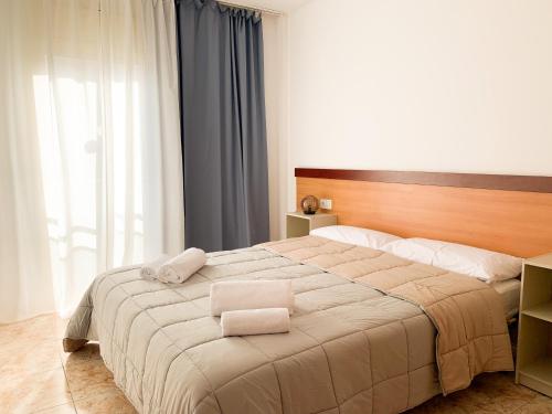 罗列特海岸Apartamentos OlaMar的一间卧室配有一张大床和两条毛巾