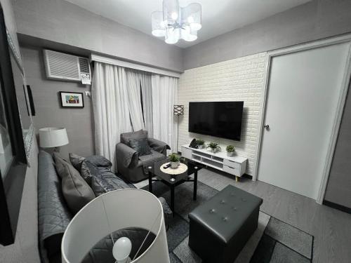 伊洛伊洛Spacious 2 Bedroom condo unit for rent的带沙发和电视的客厅