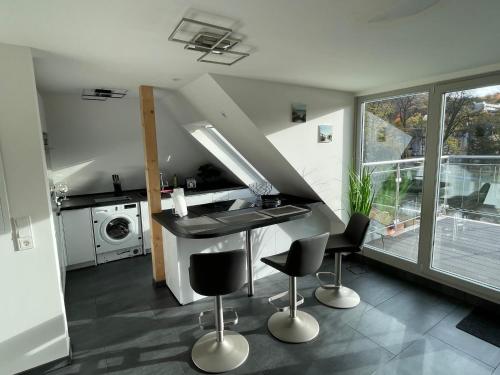 巴特诺因阿尔-阿尔韦勒Exklusive Wohnung mit Ahrblick 1 und Dachterrasse的厨房配有柜台和一些椅子