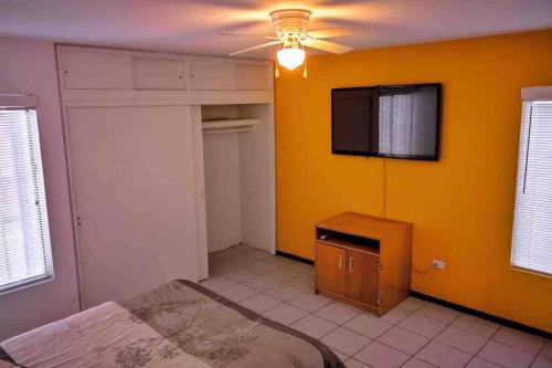 华雷斯城Departamento con Amplia Terraza en Excelente Zona的一间卧室设有一张床和黄色的墙壁