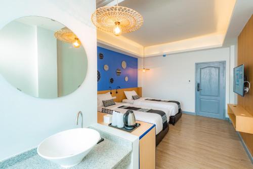 清迈Luck Thai Hotel的酒店客房设有床、水槽和镜子