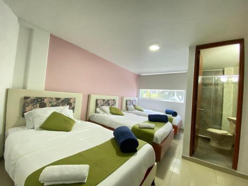 波哥大Hotel Calantha的一间带两张床的卧室和一间浴室