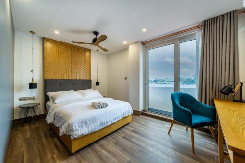 ThimarafushiStay Mikado的一间卧室配有一张床和一张蓝色椅子