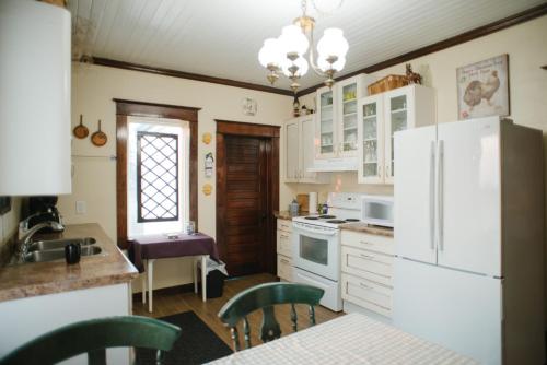 萨斯卡通Character farmhouse set in beautiful countryside的厨房配有白色家电和桌椅