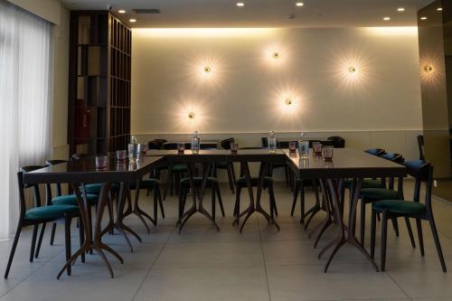 埃斯波森迪阿普利亚普拉亚酒店的配有桌椅的用餐室,墙壁靠着